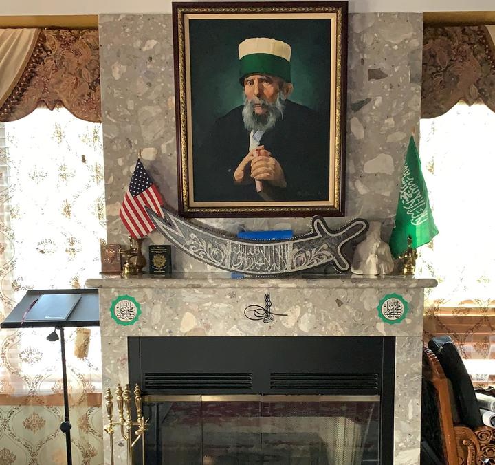 photo of arab man hanging above fireplace
