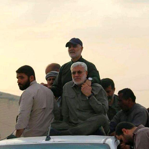 Photo of man standing with hand on another man's shoulder